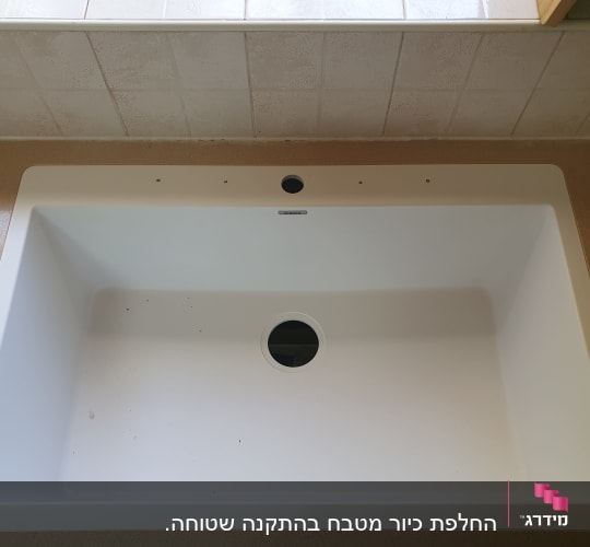 כיור מותקן על משטח שיש במטבח
